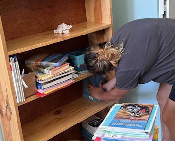 Volunteer organizing books at Women's Empowerment project in Trinidad and Tobago with IVHQ